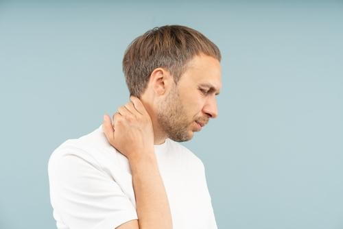Man holding his neck in discomfort from nerve-related pain