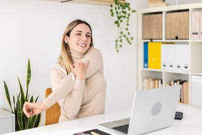 Woman practicing desk stretches to relieve tension during work