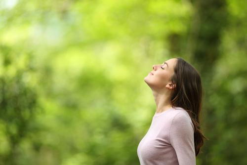 Woman practicing deep breathing exercises outdoors