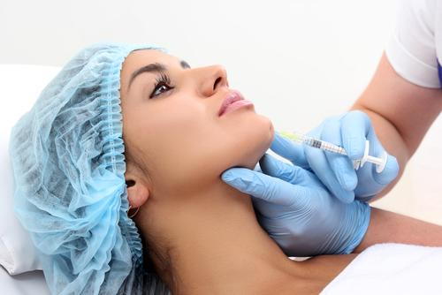 Woman undergoing cosmetic Juvederm treatment on chin