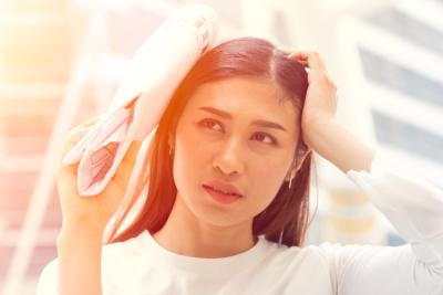 Woman-block-the-sunlight-with-paper-outside.