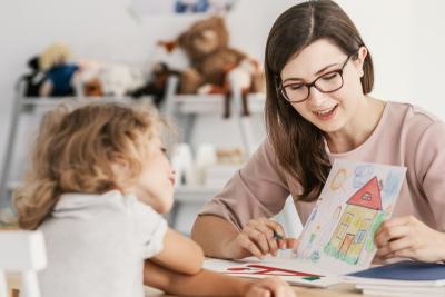 Teacher teaching a young boy with out of focus and thingking something.