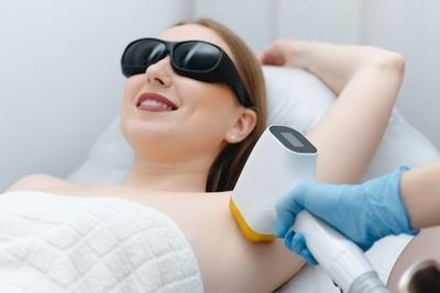 Woman-having-laser-hair-removal-in-underarm-wind-eye-protection.