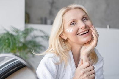 Smiling woman with cream on her face