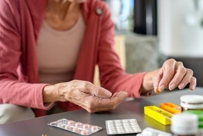 Senior woman sorting out all the meds in the table