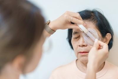 Doctor put some bondage after the eye surgery on senior woman.