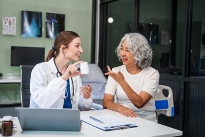 Doctor-discussing-medication-with-senior-woman-in-clinic.
