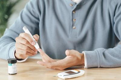 Person using glucometer to test blood sugar level