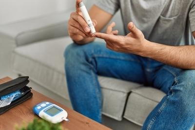 Man using glucometer to test blood sugar level