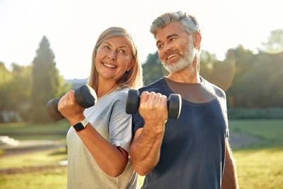 Healthy seniors doing weightlifting exercises outside