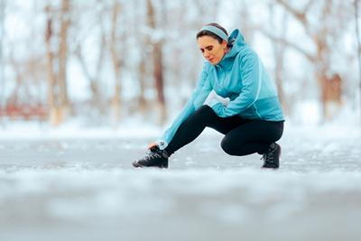 Woman holding her aching joints during cold winter weather.