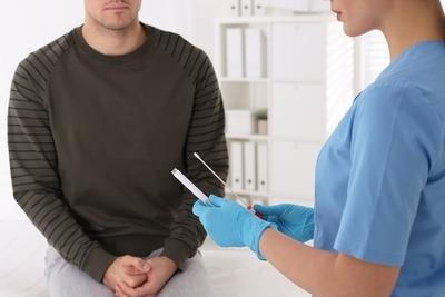 Doctor talking to a male patient with medical tools in her hand