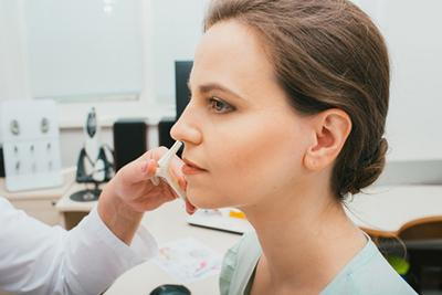 Doctor checking the sinus of a woman patient on clinic