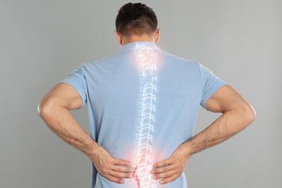 Man suffering in back pain with spine highlights in white.