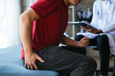 Male patient consulting doctor about hemorrhoid treatment