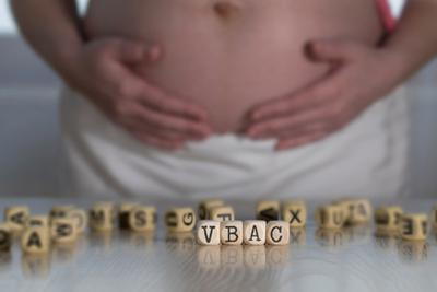 A-pregnant-woman-holding-her-tummy-with-blocks-in-table.