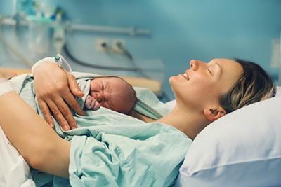 Postpartum moment—woman holding baby after unmedicated birth