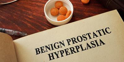 Book page showing “Benign Prostatic Hyperplasia” with pills and a pen nearby