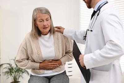 Senior woman with abdominal pain consulting doctor for treatment options