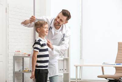 Doctor measuring the heights of a little boy.