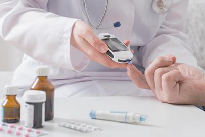 Doctor getting some blood sugar of the patient using glocometer