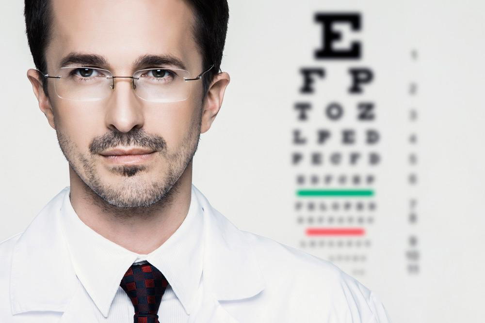 Man wearing eye glasses and reading chart