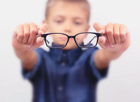 A kid holding eye glasses