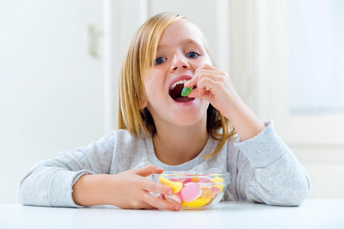 kid eating candy before seeing dentist for Suffolk pediatrics