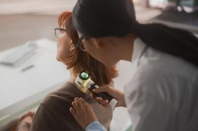 Doctor checking the skin condition in the back of patient