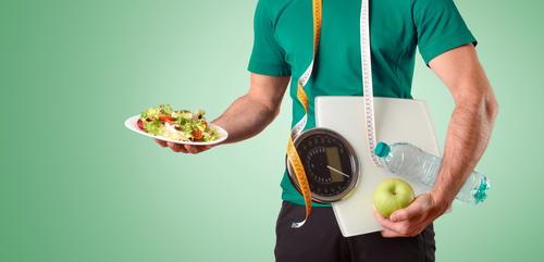 Man-holds-salad-scale-apple-water-and-tape-measure