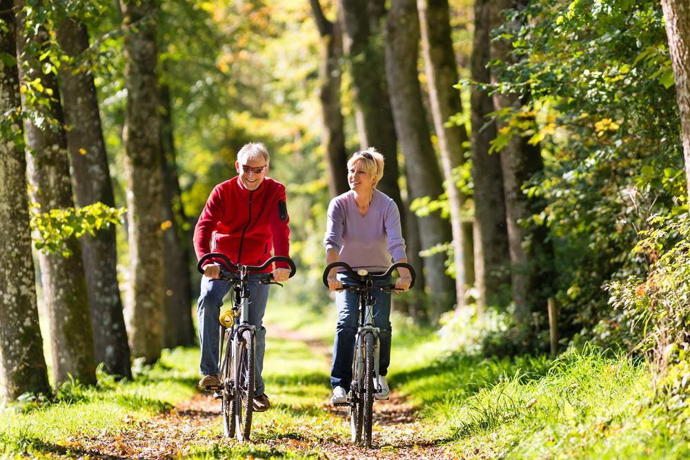 Elderly Couple Riding Bikes in Park