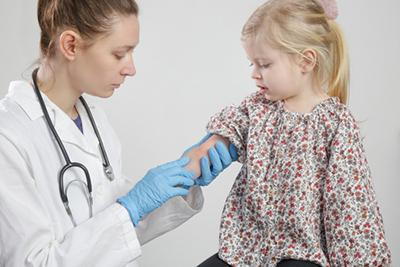 Pediatrician examining a child with rash on the skin