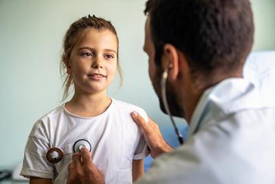 Pediatrician examining child during pre-participation sports physical