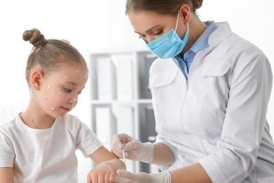 Doctor cleaning the wound on little grils arms