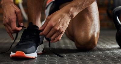 Man tying supportive athletic shoes before workout session