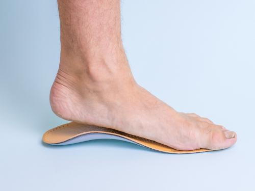Foot wearing an orthotic insole for support and alignment.