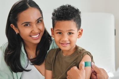 Mother and child smiling after child immunization shot