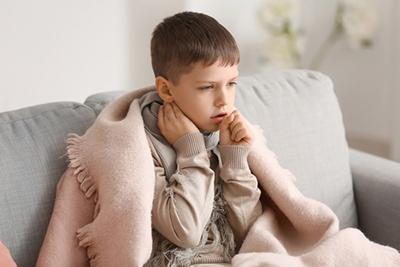 Young boy wrap in blanket with fever and cough