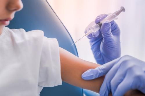 Pediatrician giving a vaccine shot to a young child in a clinic