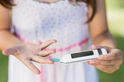 Young girl getting her sugar level thru glocometer