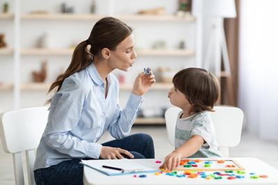 Teacher teaching the child to pronounce on study room.