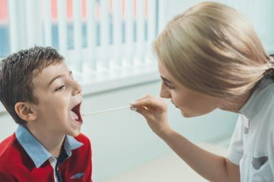 Young boy suffering front strep throat check by the doctor