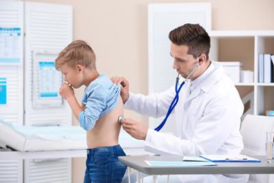 Doctor check the back of a boy with cough on clinic.