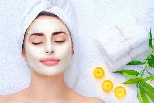 Woman-with-a-facial-mask-relaxing-with-candles-and-towels.