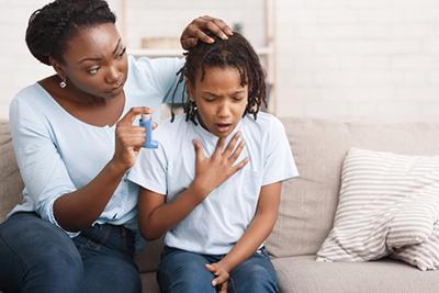 Young-girl-with-asthma-holding-her-chest-with-mother-beside-her.