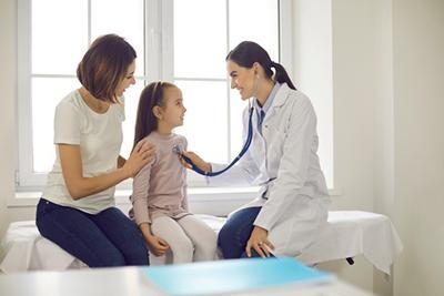 Mother and daughter at pediatrician's office for school physical