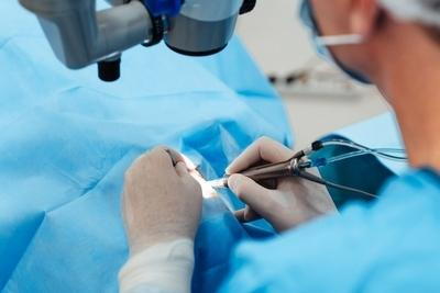 Surgeon-performing-delicate-operation-with-microscope