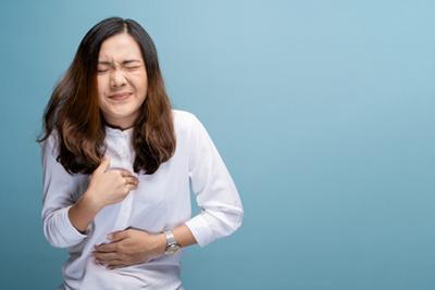Asian-woman-suffering-in-Acid-reflux-holding-chest.