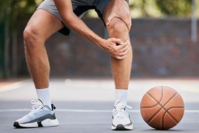 Basketball player suffering from toepain with the ball on the ground