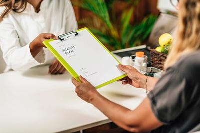 Female client reviewing health plan documents with provider.